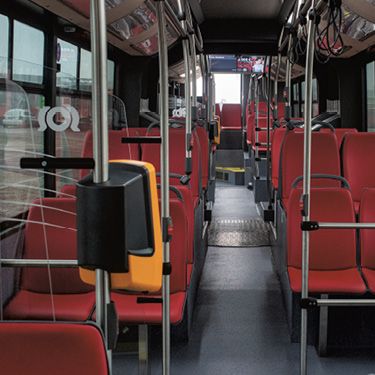 Interiér nového CNG autobusu s komfortnými červenými sedadlami.
